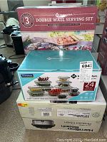 Photo showing Members Mark Double Wall Serving Set box, Members Mark 24-piece Glasslock food storage set box, and Hamilton Beach Roaster Oven box stacked.