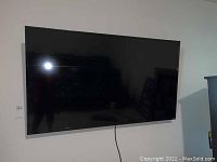 Wall-mounted TV front view showing overall condition and screen size