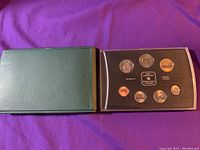 Opened green hard case with black insert displaying 8 Canadian coins from 2001 specimen set.
