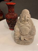 Photo showing both the Buddha statue and the red Chinese dragon vase together on a table