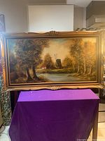 Full view of large framed oil painting on canvas depicting a Dutch windmill and cabin scene by a pond with trees.