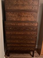 Front view of stacked drawers showing wood grain laminate finish and drawer knobs.