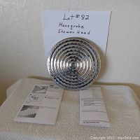 Chrome 10-inch diameter Hansgrohe Raindance Downpour Air showerhead with instructions laid out in front.