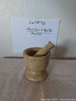 Marble mortar and pestle set with hand-written sign indicating lot number and description.