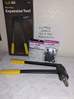 PEX Pipe Expansion Tool with handles, two bags of connectors and clips in original packaging with box