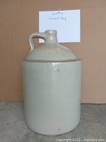 Full front view of the vintage stoneware crock jug, showing the jug's body and handle.
