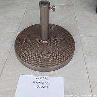 Metal umbrella stand with textured bronze circular base and two adjustable clamps for umbrella pole