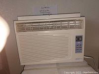 Front-facing view of WINTAIR window air conditioner showing vent louvers, ventilation slats, and digital control panel on right side.