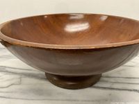 Side view of the huge teak pedestal bowl showing the curved shape and pedestal base.