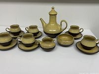 Full view of the complete two-tone ceramic tea/coffee set arranged on table showing the teapot, coffee pot, cups with saucers, creamer, and sugar bowl with lid in mid-century modern style.