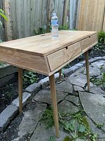 Side-angle view of desk outdoors with water bottle on top