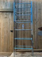 Full view of the tall chrome framed shelf with six glass shelves, showing the entire unit from front, the beveled glass and chrome frame.