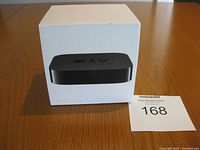 Apple TV in original packaging box on wooden table
