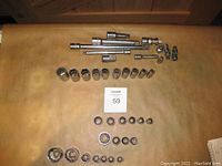 Photo showing full set of sockets, extensions, swivel joints, and reducer arranged on a surface.