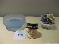 Photo of the three items: blue glass frog bowl, ceramic Beefeater mug, and porcelain floral figurine