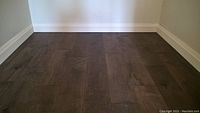 Installed view of smokey house distressed maple engineered hardwood flooring in a small corner space with baseboard trim.