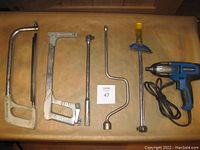 Photo of Mastercraft impact driver, speed handle driver, torque wrench, two hack saws, and breaker bar on a brown surface.