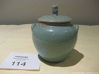 Front view of the 1950s blue speckled ceramic honey pot with owl finial lid and two side handles.