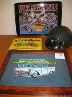 Wide view showing Harley Davidson metal sign, motorcycle helmet, Indian motorcycle cloth patch, and wood shadow box with vintage car illustration.
