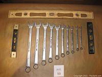 Full view of all 10 Snap-On SOEX wrenches laid beside three levels (one wooden, two black) on a flat surface.