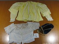Overview of two vintage ladies tops (yellow and white cotton) and a dark blue velvet lined hat.