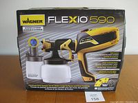 Front view of Wagner Flexio 590 paint sprayer box showing branding and product image.