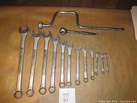 Photo showing full set of Craftsman wrenches, Mastercraft ratchet, Proto speed handle and long handle tool bar arranged on a brown surface.