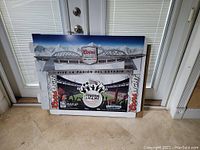 Cardboard 3D advertising display for Coors Light beer designed as a soccer stadium poll topper with Liga MX branding, shown folded against a door.