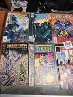 Photo showing comics like Hawkman, Green Hornet, Swamp Thing, Tyrant, and Countdown to Alien Legion on table.