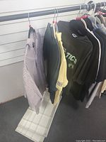Long and short sleeve men's shirts and tops in various colors and styles hung on hangers