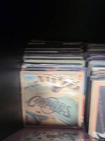 Stack of vinyl records with a cover featuring an abstract design and the word "American" visible.