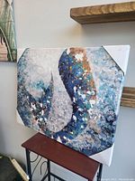 Abstract painting with textured blue, white, and brown areas wrapped at the edges.