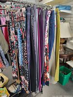 Hanging pants on rack showing variety of styles, colors including floral, solid, and patterns