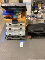 Full view of stacked tackle boxes and storage bins holding various household repair items and adhesives.