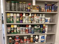 Full view of shelves with various cans and tubes of paint, glue, fillers, sprays and maintenance products.