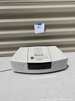 Front view of the white Bose Wave AWRC-1P stereo radio/CD player showing curved speaker grills and black display area.