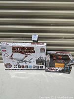 Boxed Striker Spy Drone and Leader RC climbing truck side by side on concrete floor