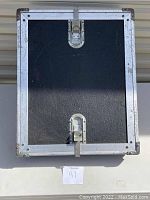Front view of black heavy duty speaker case with metal edge reinforcements and latch closures.