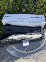 Yamaha Venova instrument in black plastic case with the white original box behind it on a glass table.