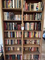 Full double-wide bookshelf showing six shelves filled with a mix of hardcover and paperback books.