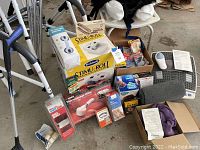 Overall view of the lot with crutches, walkers, body and foot massagers, shower seat, grab bars, and various small boxed health supplies arranged on the ground.