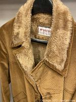 Close-up image showing McGregor corduroy coat with tan fur-lined collar and inside lining