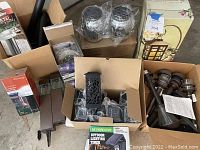 Overview photo showing multiple solar lights, boxes, and packages including stake lights and lanterns.