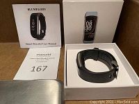 New Blumelody smart bracelet in its box with user manual and packaging visible.