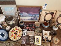 Wide view of lot showing pottery, baskets, pillows, paintings, and paper goods