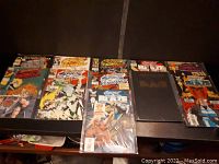 Photo of the spread out comic books showing various Ghost Rider issues including some with distinct cover art. Comics are on a dark surface.