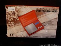 Photo of the unopened box for Digital Scale Professional-Mini showing the image of the scale and battery requirements.