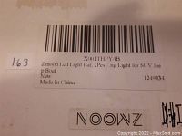 Close-up photo of the product box label showing model number X001THPY4B, brand Zmoon, and description as LED Light Bar 2pcs for SUV, Jeep, or boat. It indicates new condition and Made in China.