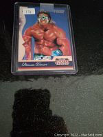 Front view of the Ultimate Warrior numbered proof card in a protective sleeve showing the wrestler in full color with a label indicating number 131 (possibly inventory).