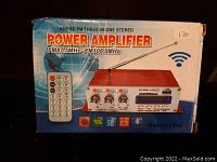 Box front with image and key features of the USB SD FM three-in-one stereo power amplifier alongside its remote control.